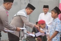 Kapolres Probolinggo AKBP Wisnu Wardana memberikan santunan kepada anak yatim.